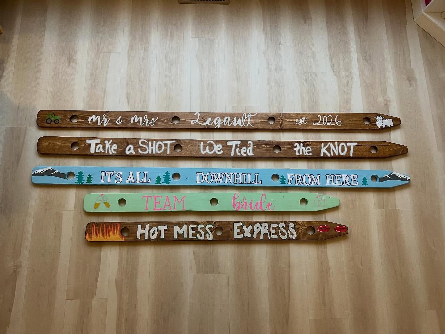 A collection of personalized wooden shot skis made by Lumber and Brush