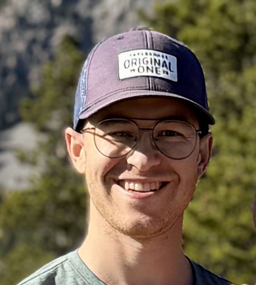 Shayne Legault smiling outdoors in the mountains